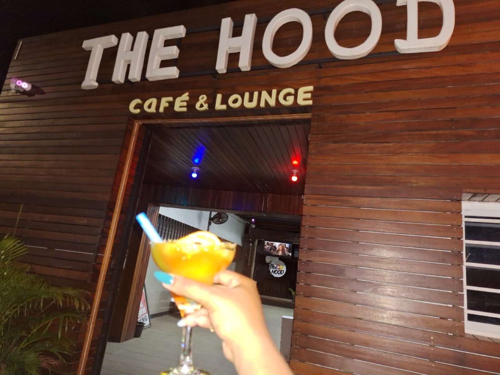 The Hood Café & Lounge bij avond met een cocktail in de hand